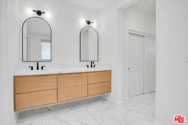 a bathroom with a double vanity sink and a mirror