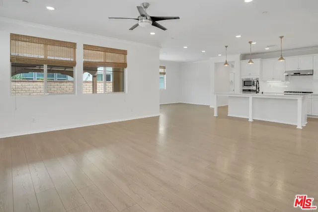 a view of kitchen with kitchen island wooden floor center island and stainless steel appliances