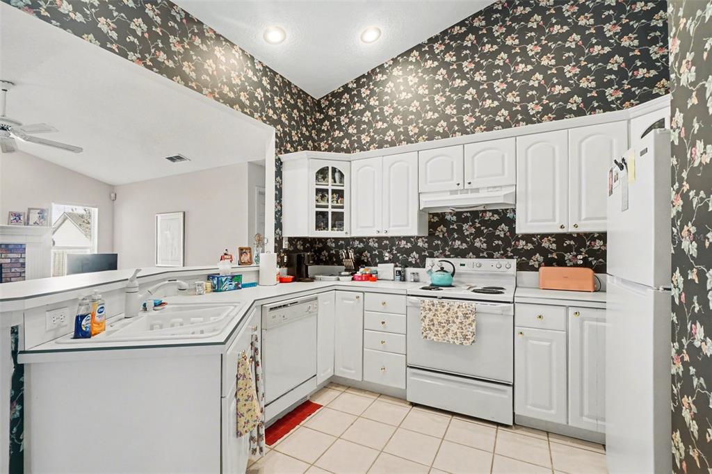 1670 East Spring Ridge Circle Winter Garden, FL 34787 - Photo 12 of 30 a kitchen with cabinets a sink and white appliances