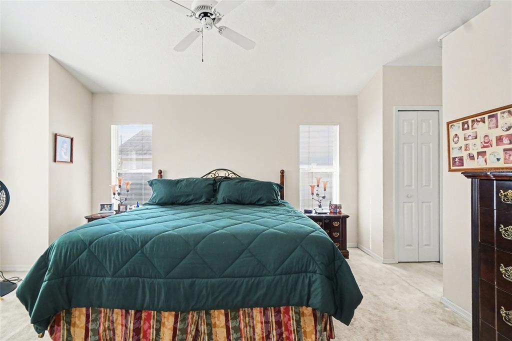 1670 East Spring Ridge Circle Winter Garden, FL 34787 - Photo 17 of 30 a bedroom with a bed and a chandelier