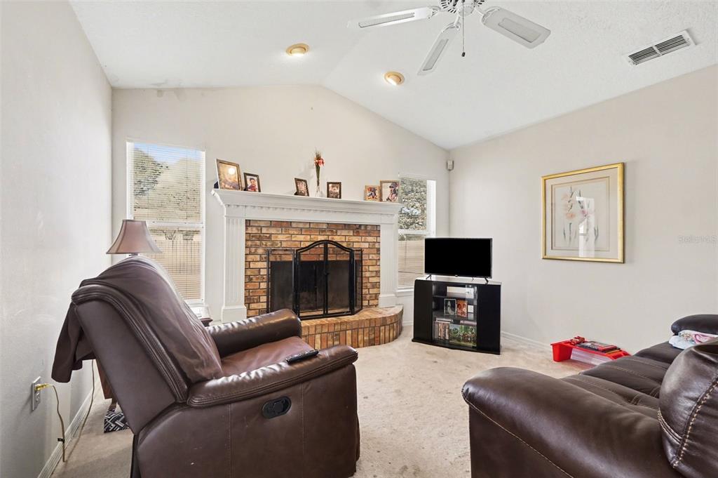 1670 East Spring Ridge Circle Winter Garden, FL 34787 - Photo 5 of 30 a living room with furniture a flat screen tv and a fireplace