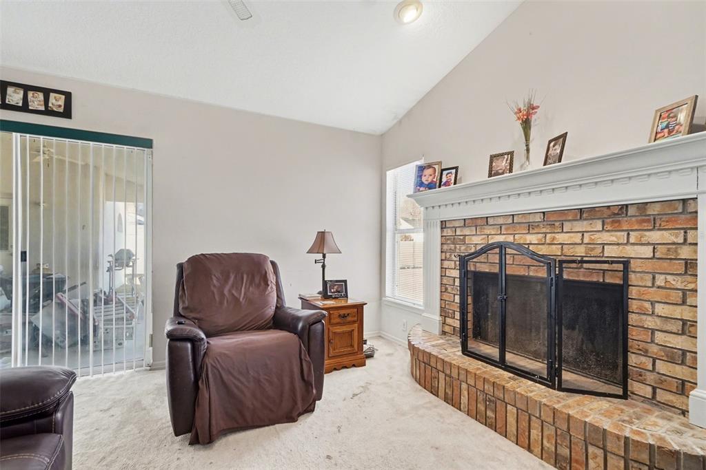1670 East Spring Ridge Circle Winter Garden, FL 34787 - Photo 8 of 30 a living room with furniture a flat screen tv and a fireplace
