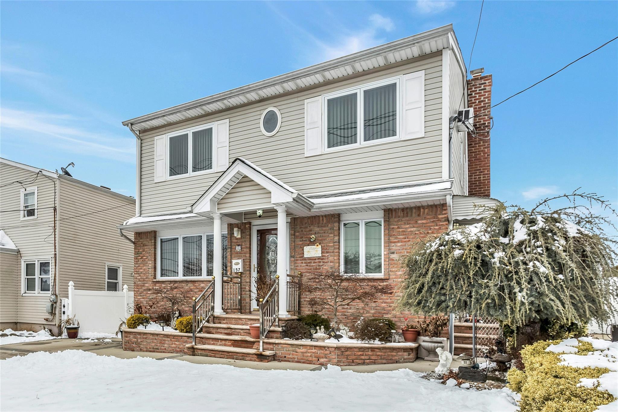 a front view of a house with a tree