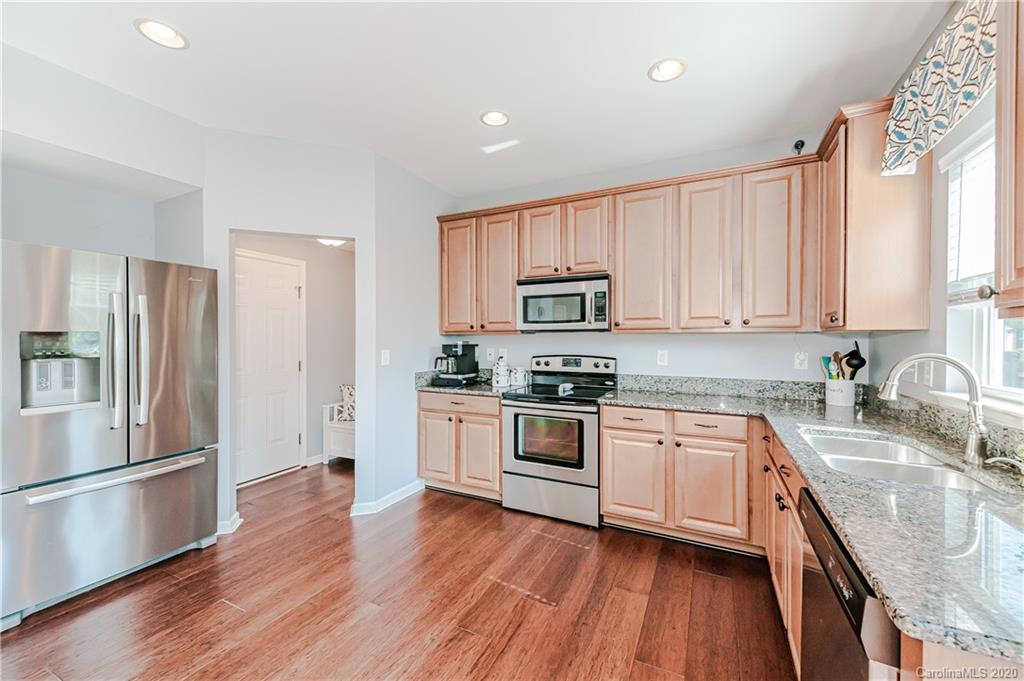 640 Alsace Lane Fort Mill, SC 29708 - Photo 13 of 36 a kitchen with stainless steel appliances granite countertop white cabinets a refrigerator a sink a stove a microwave and wooden floors