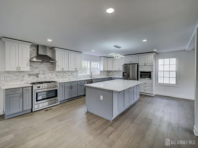 a kitchen with kitchen island granite countertop a sink stove and refrigerator