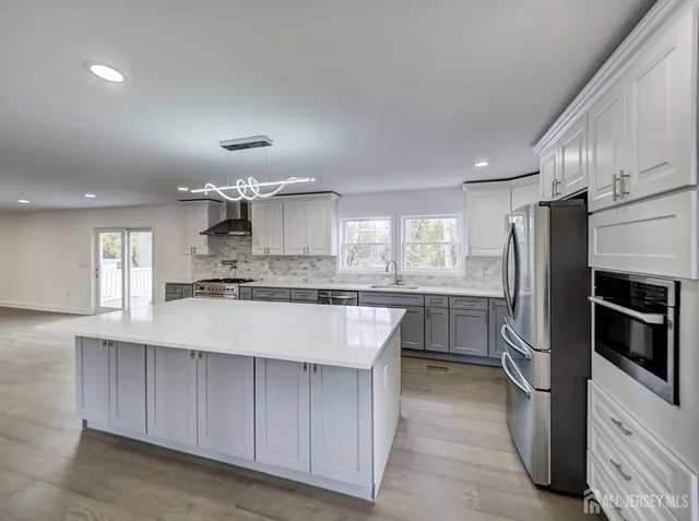 a large kitchen with a large counter top stainless steel appliances and cabinets