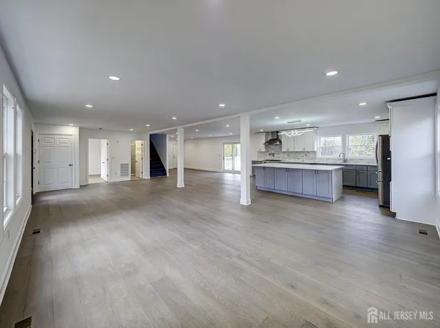 a view of a big room with wooden floor and windows