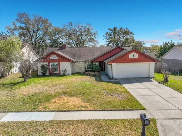 a front view of house with yard and trees in the background
