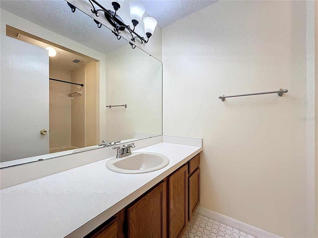 2843 Danforth Drive Orlando, FL 32818 - Photo 14 of 41 a bathroom with a sink a mirror and a shower