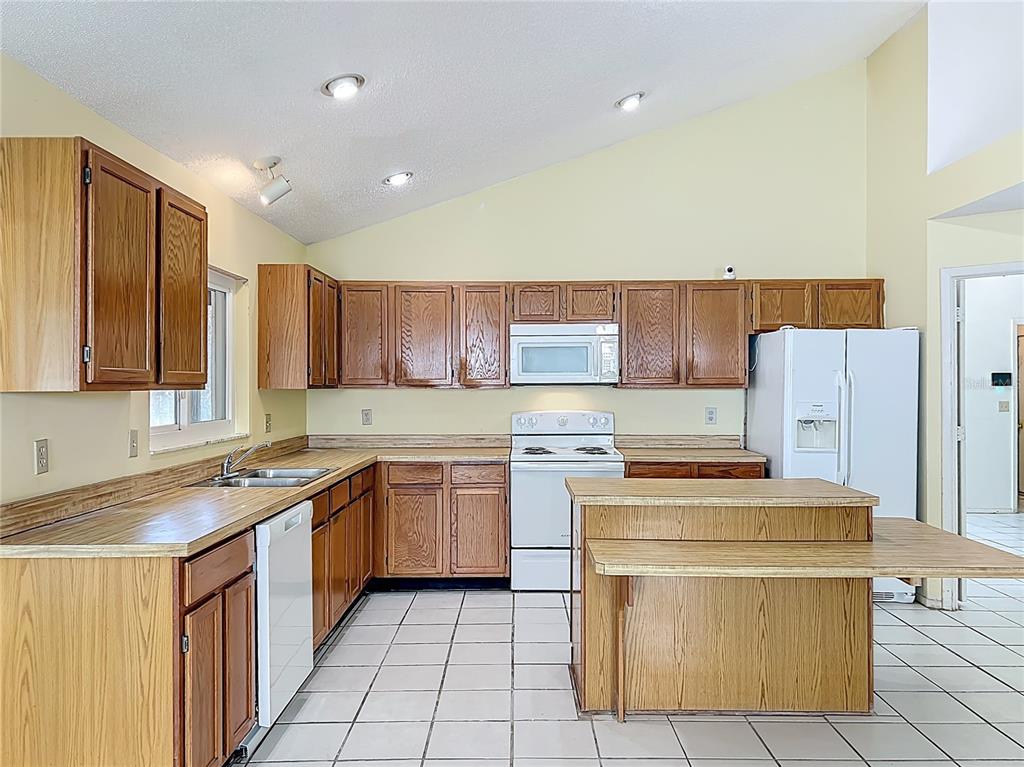 2843 Danforth Drive Orlando, FL 32818 - Photo 18 of 41 a kitchen with a stove top oven sink and cabinets