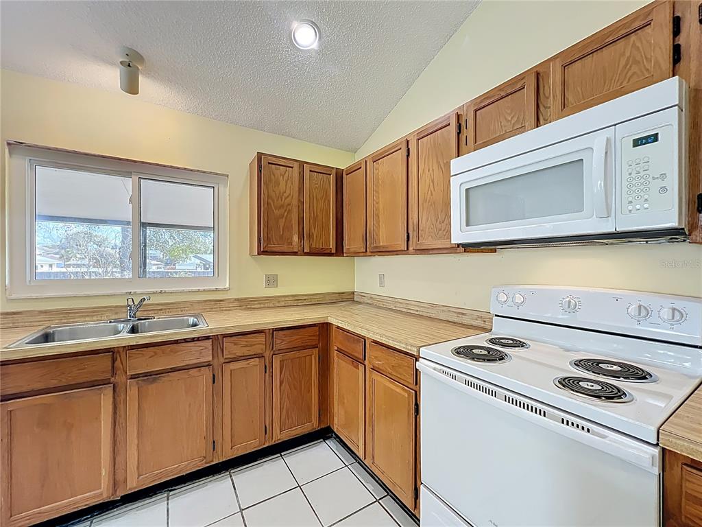 2843 Danforth Drive Orlando, FL 32818 - Photo 20 of 41 a kitchen with a sink stove and microwave