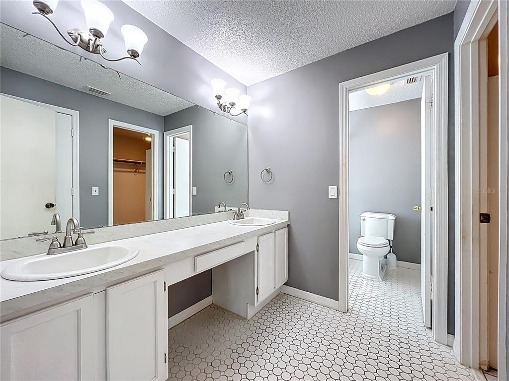 2843 Danforth Drive Orlando, FL 32818 - Photo 33 of 41 a spacious bathroom with a double vanity sink a toilet and a mirror