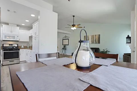 a kitchen with stainless steel appliances granite countertop a sink a stove and cabinets