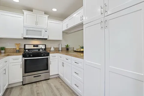 a kitchen with cabinets stainless steel appliances and a counter space