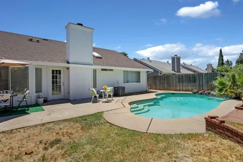 a view of a house with backyard and sitting area