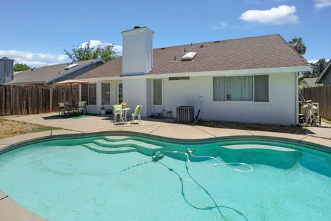 a swimming pool with outdoor seating and yard