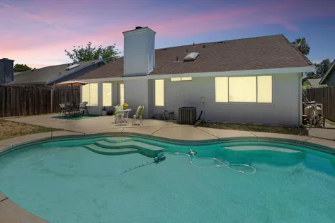 a swimming pool with outdoor seating and yard
