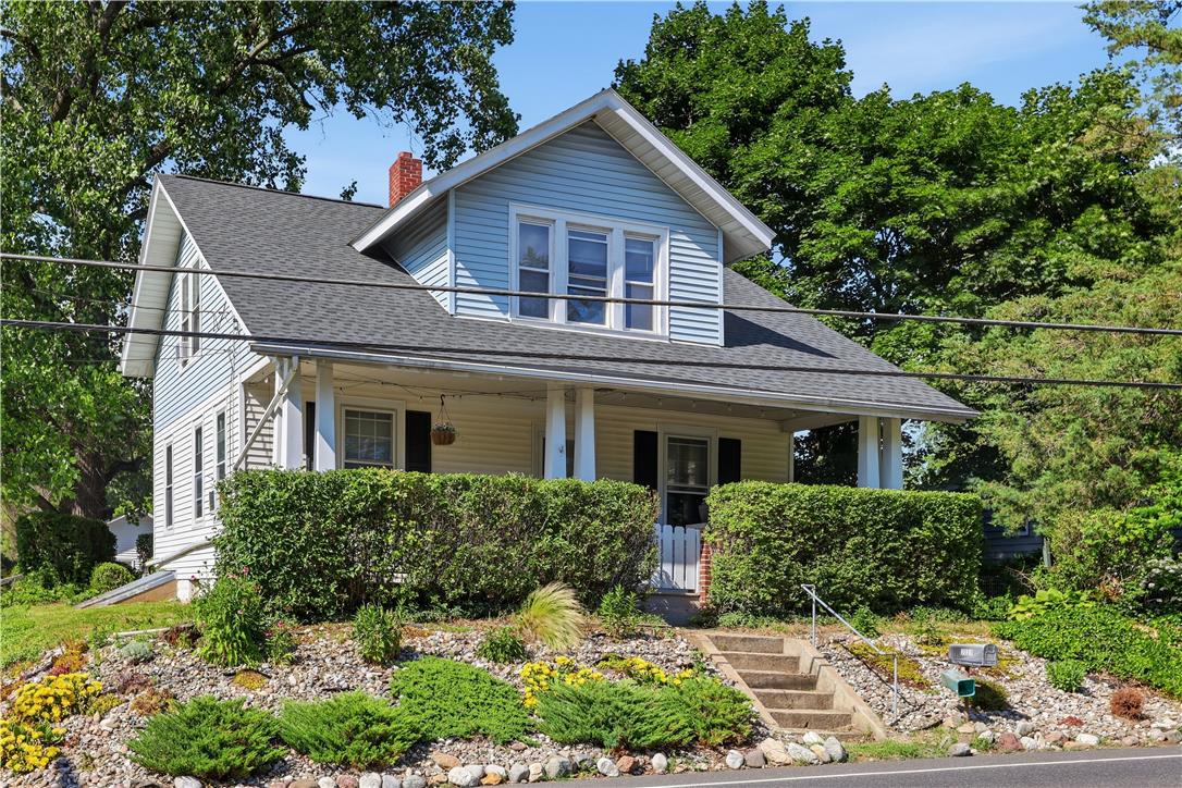 Charming gable-roofed home with inviting front porch and mature landscaping creates delightful curb appeal.
