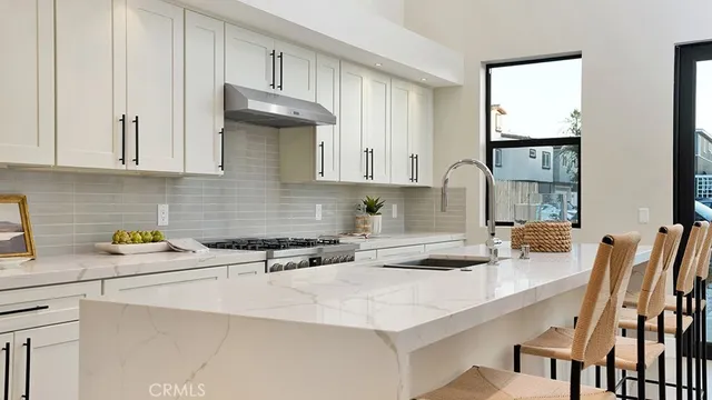 a kitchen with stainless steel appliances granite countertop a sink a stove and cabinets