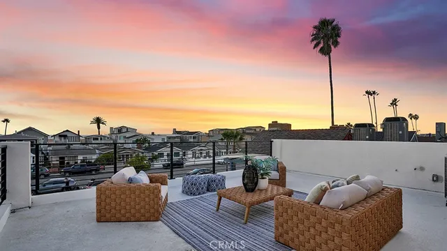 a view of roof deck with couches and sky view