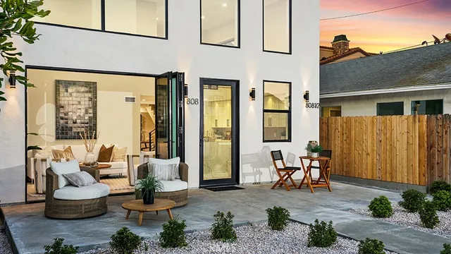 a view of a patio with couple of chairs and a potted plant