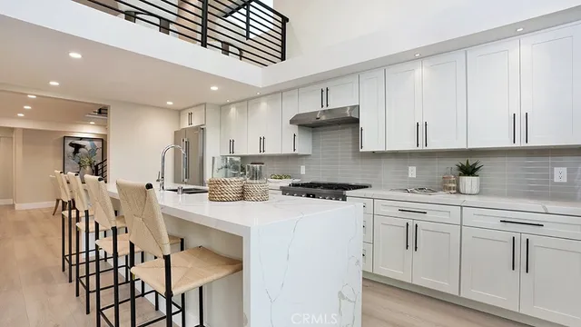 a kitchen with white cabinets stainless steel appliances and sink