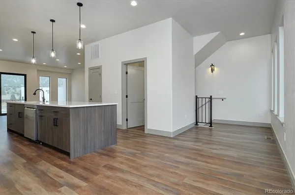 a view of a big room with wooden floor and windows