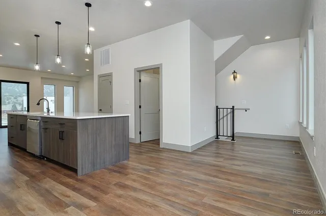 a view of a big room with wooden floor and windows