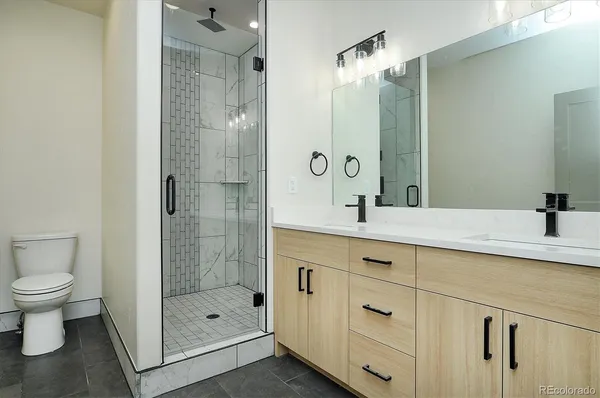 a bathroom with a shower sink vanity and mirror