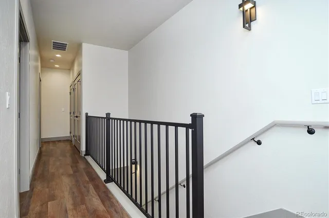 a view of a hallway with wooden floor