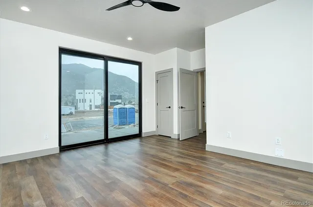 an empty room with wooden floor and windows