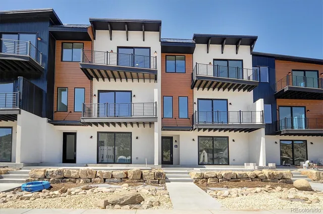 a front view of a building with a yard and barbeque oven