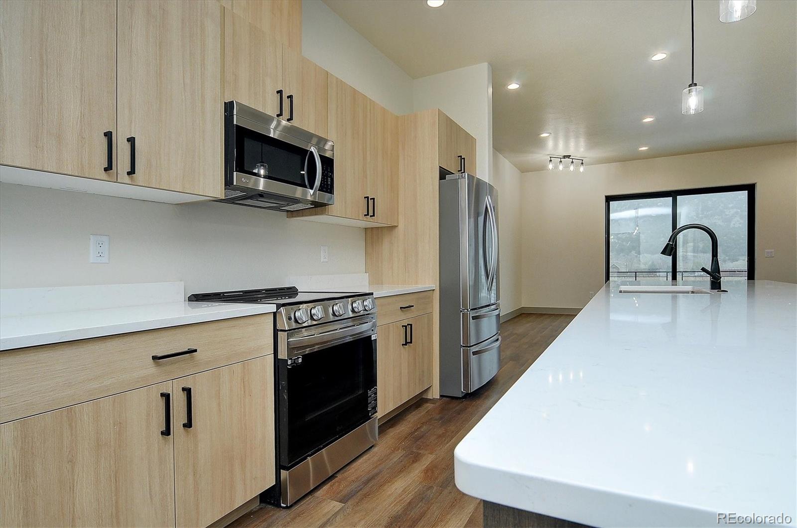 6398 Cleora Road, Unit F Salida, CO 81201 - Photo 7 of 34 a kitchen with stainless steel appliances a stove microwave and sink