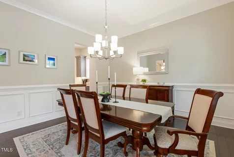 a kitchen with stainless steel appliances kitchen island granite countertop a dining table chairs and a refrigerator