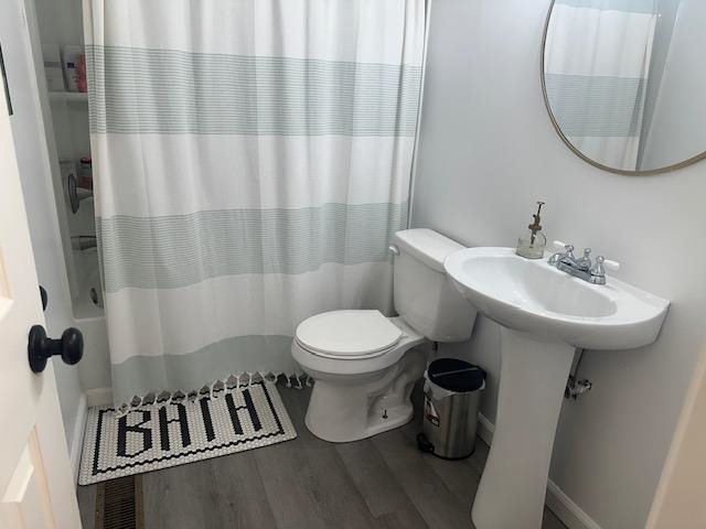 440 Angotti Road Crump, TN 38327 - Photo 17 of 30 Bathroom featuring hardwood / wood-style floors, shower / bath combo, and toilet