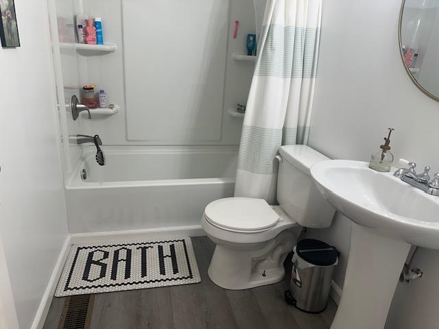 440 Angotti Road Crump, TN 38327 - Photo 18 of 30 Bathroom with toilet, hardwood / wood-style floors, and shower / tub combo with curtain