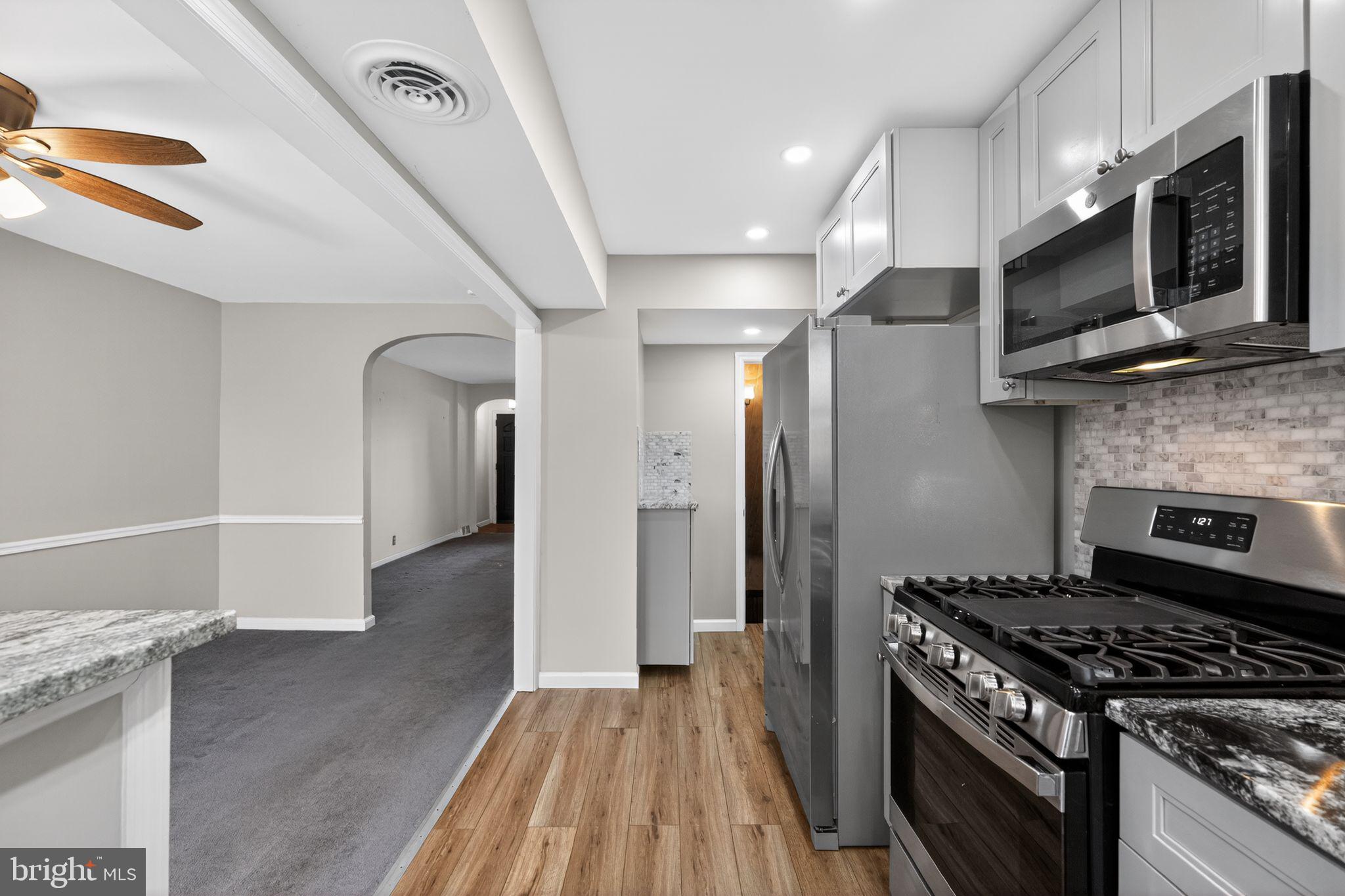 1017 Tyson Avenue Philadelphia, PA 19111 - Photo 11 of 23 a kitchen with stainless steel appliances kitchen island granite countertop a stove and a wooden floors
