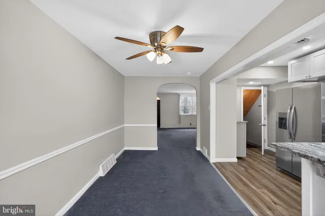 a view of a hallway with a chandelier fan