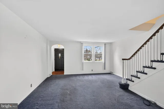 a view of an empty room with stairs and a window