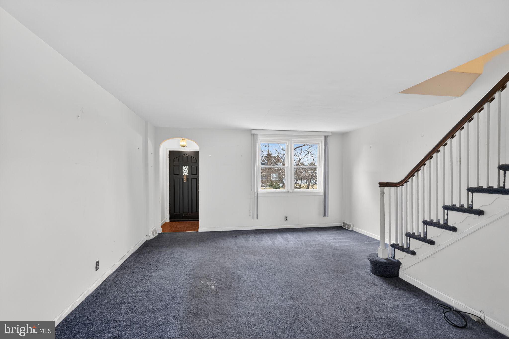 1017 Tyson Avenue Philadelphia, PA 19111 - Photo 5 of 23 a view of an empty room with stairs and a window