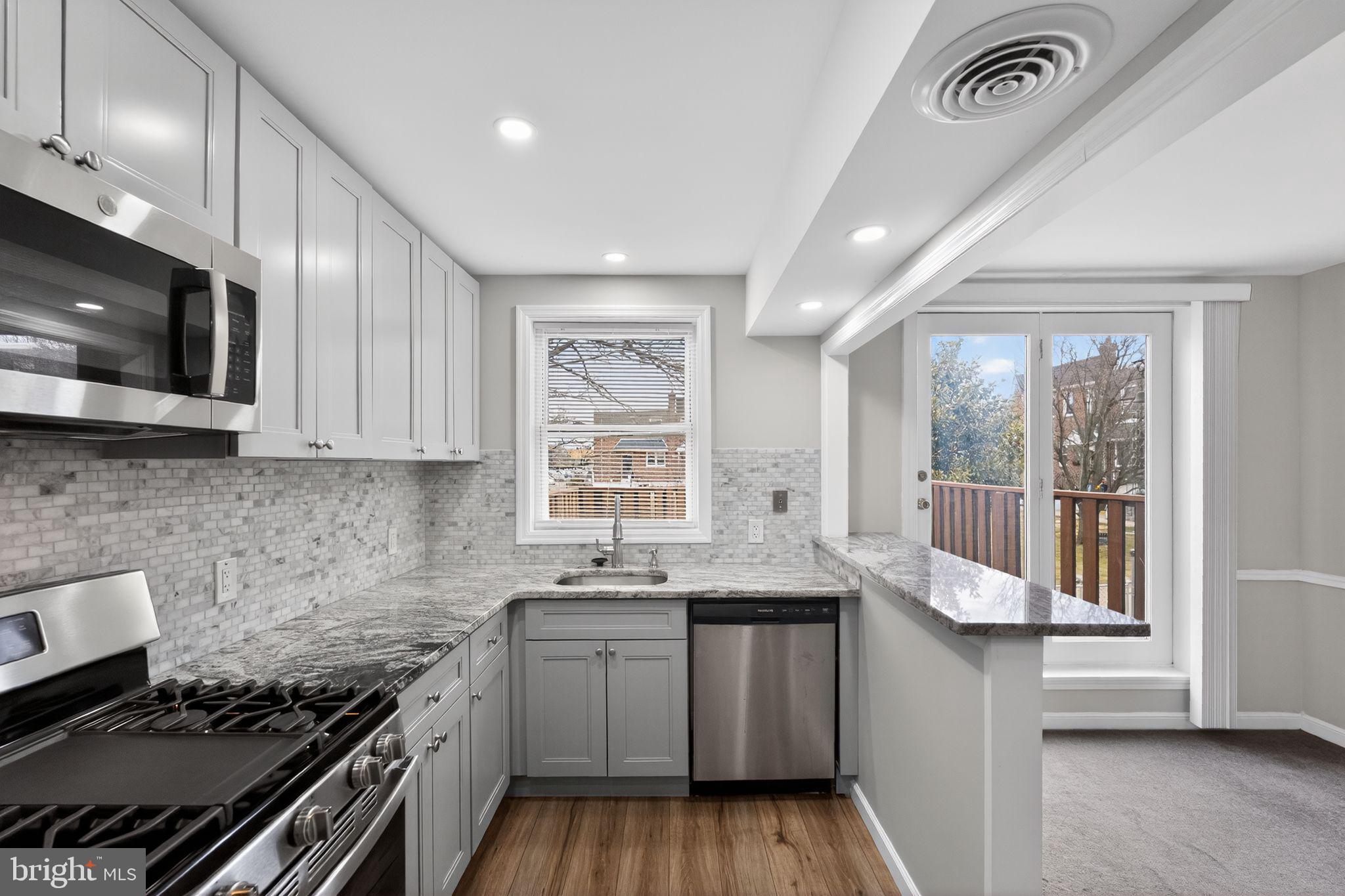 1017 Tyson Avenue Philadelphia, PA 19111 - Photo 9 of 23 a kitchen with granite countertop a sink a stove and cabinets