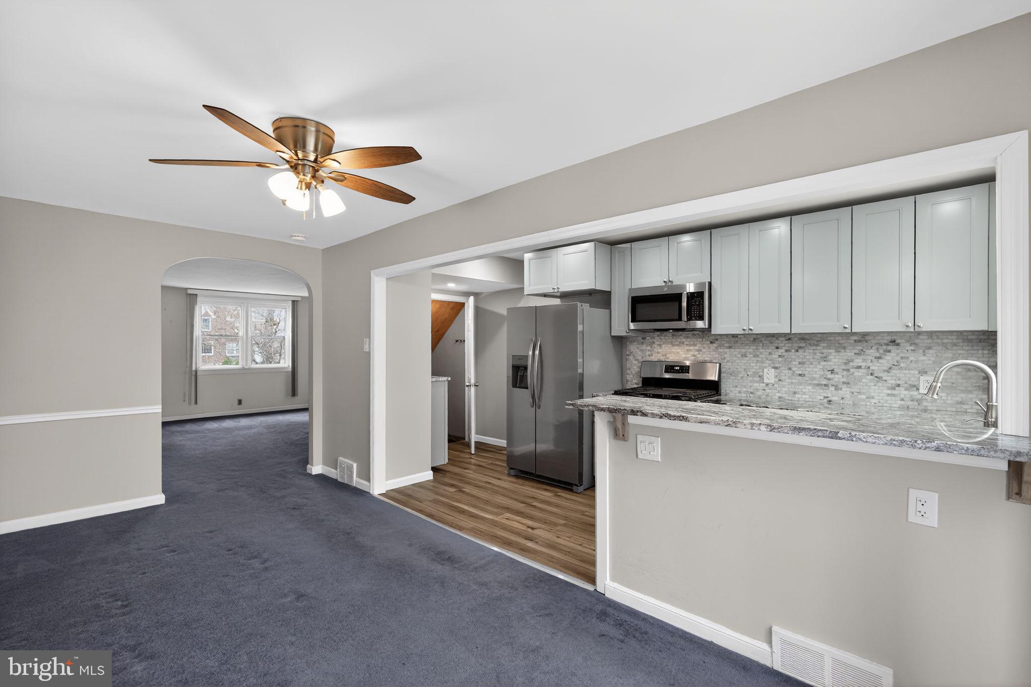 1017 Tyson Avenue Philadelphia, PA 19111 - Photo 10 of 23 a kitchen with stainless steel appliances granite countertop a stove a sink dishwasher and a refrigerator with white cabinets