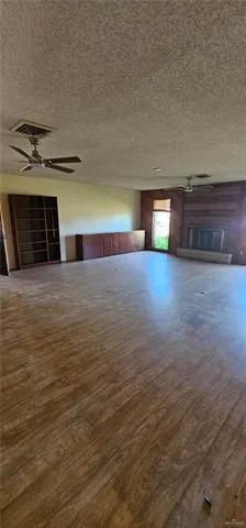 a view of an empty room with a fireplace and a window