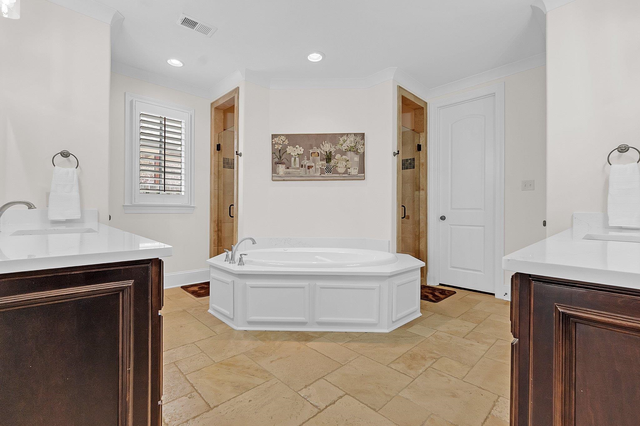 3246 North Hartwell Ridge Drive Collierville, TN 38017 - Photo 24 of 40 Bathroom featuring a central built-in soaking tub, dual vanity areas with white countertops, and two separate shower enclosures with glass doors