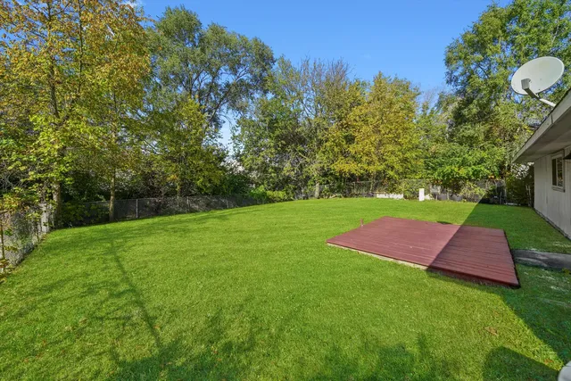 a backyard of a house with yard and trampoline