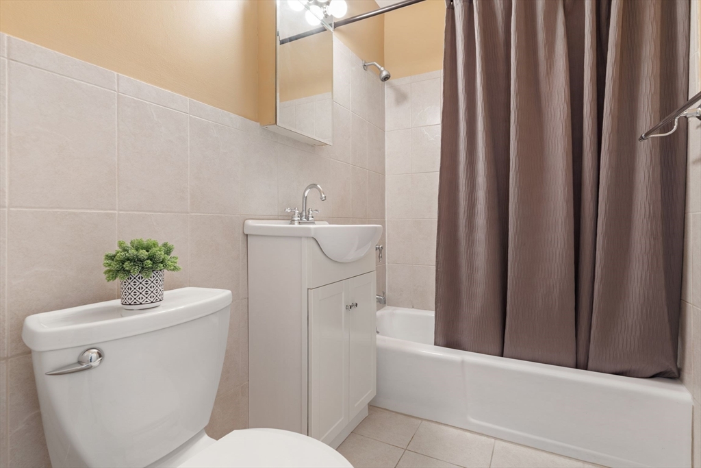 22 Branchfield Street, Unit D1 Boston, MA 02124 - Photo 12 of 20 a bathroom with a sink a toilet and shower curtain