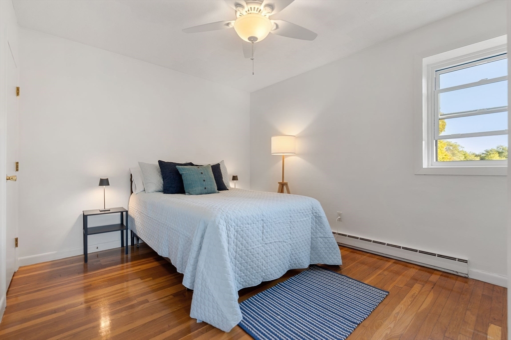 22 Branchfield Street, Unit D1 Boston, MA 02124 - Photo 14 of 20 a bedroom with a bed and wooden floor