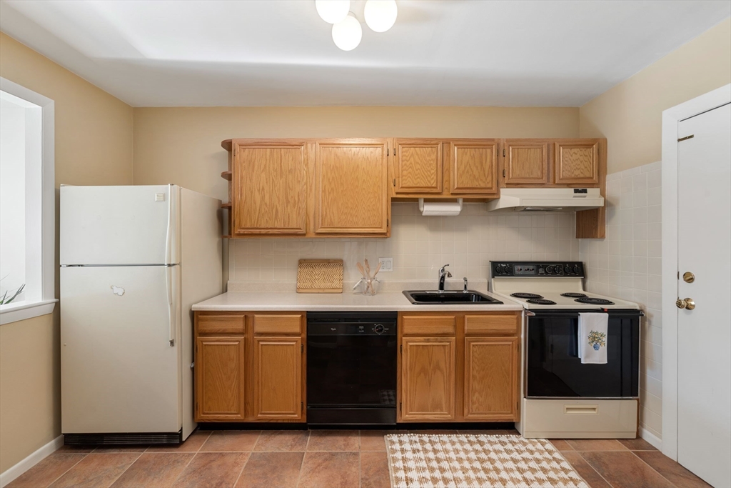 22 Branchfield Street, Unit D1 Boston, MA 02124 - Photo 8 of 20 a kitchen with a sink a stove and refrigerator