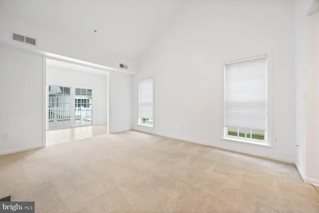 a view of a room with wooden floor and a ceiling fan
