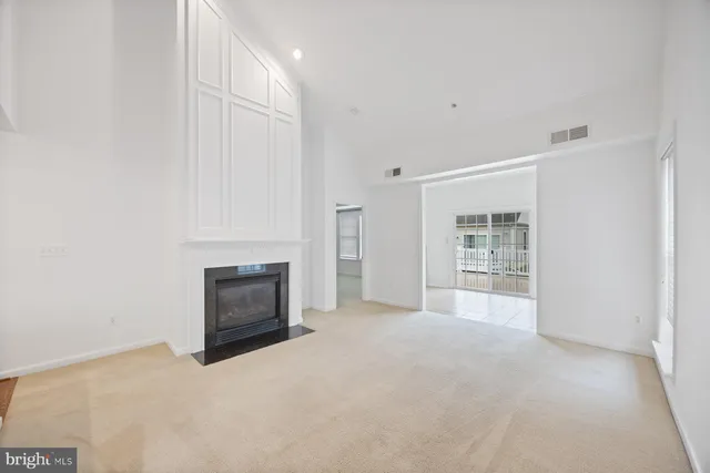 a view of an empty room with a fireplace and a window